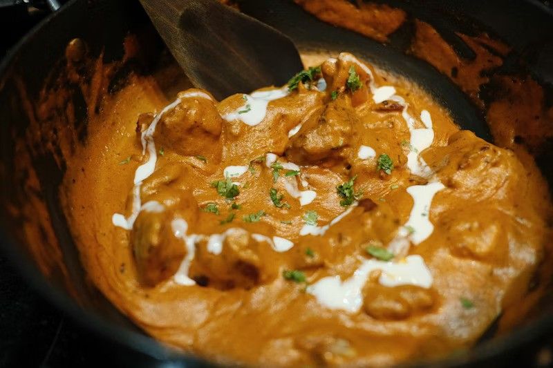 Authentic Punjabi Butter Chicken with creamy tomato sauce and cream swirl